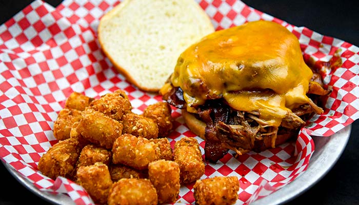 The best bacon cheese burger topped with smoked pulled pork and side of fries from the Menu at the Mess Hall Tavern and Grill VFW Post 1215 Rochester Minnesota.