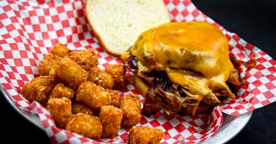 Bacon cheeseburger topped with smoked pork and a side of tater tots at the Mess Hall Tavern and Grill in Rochester, MN at the VFW Post 1215.